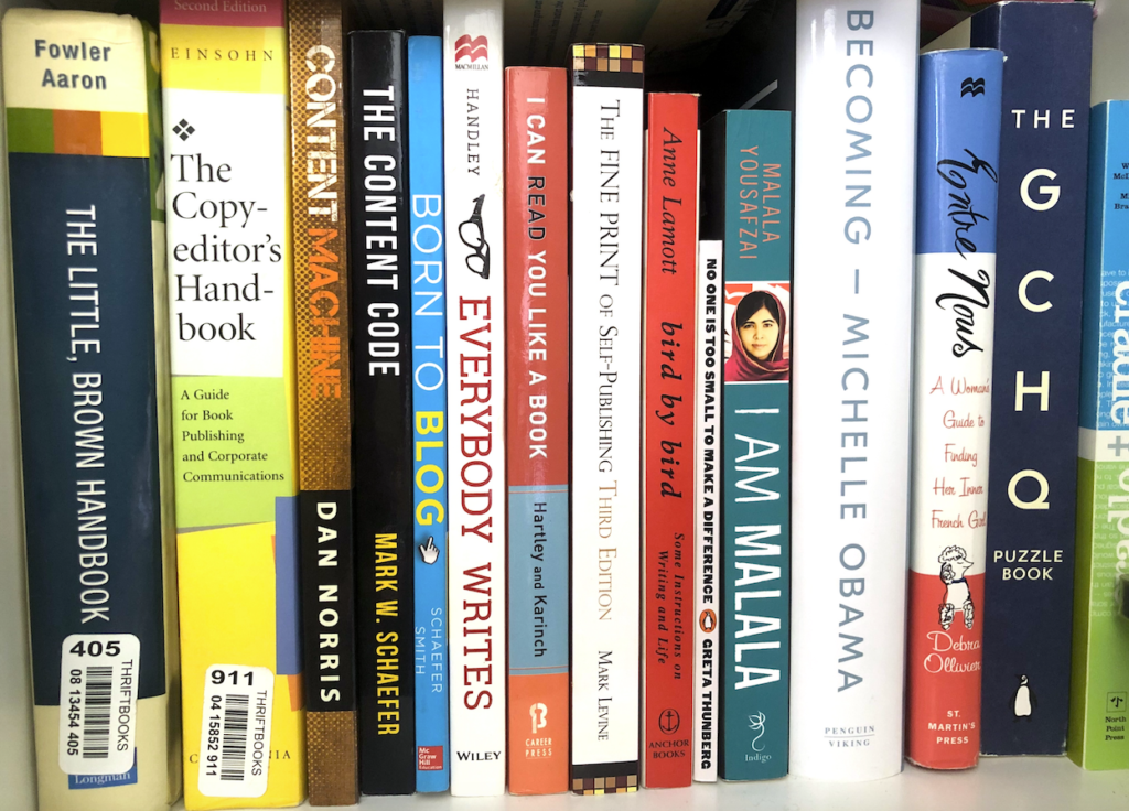a bookshelf with writing and nonfiction books lined up 