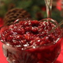 Homemade chunky cranberry sauce in a glass bowl with a spoon