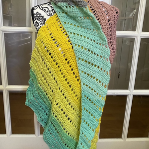 Colorful crochet shawl draped on a dress form
