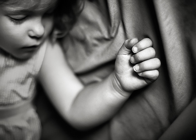 black and white photo of Sleeping Child with closeup of hand by Jay Ryness