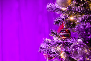 Decorated Christmas tree close up. Purple neon lights