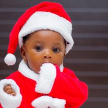 Beautiful black baby dressed in little Santa Claus costume