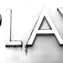 silvery metallic sign spelling out 'play' in plain capital letters