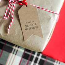 gifts wrapped in brown paper with red and white string. Tag says 'Made in Santa's Workshop'