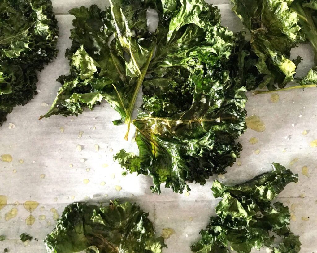 Air fried kale leaves on a plain white background