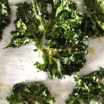 Air fried kale leaves on a plain white background
