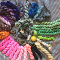 An assortment of mini skeins on a striped sheet